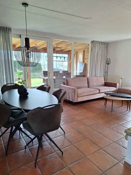 Panoramascheibe über die ganze Breite des Strandhauses Blickrichtung See Garten und Palmen