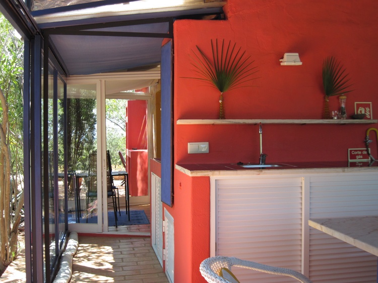 Der Uerebergang vom Wintergarten hin in die farbenfrohe und gut bestueckte Kueche.