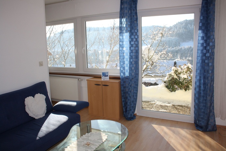 Wohnzimmer mit Blick auf den verschneiten Garten