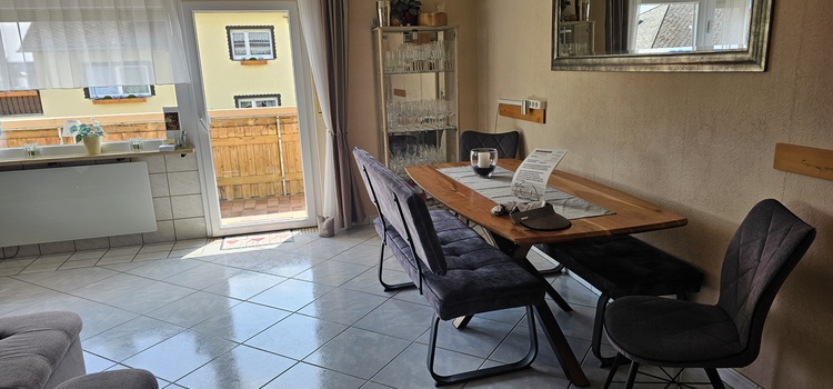 Essgelegenheit im Wohnzimmer für 8  Gäste und Zugang zum Balkon