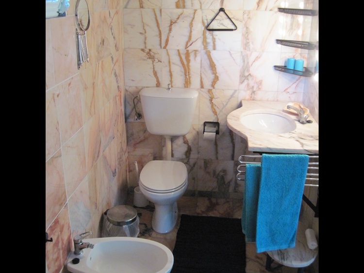 Das Badezimmer ganz in Marmor gehalten mit WC und Bidet und Dusch-Badewanne
