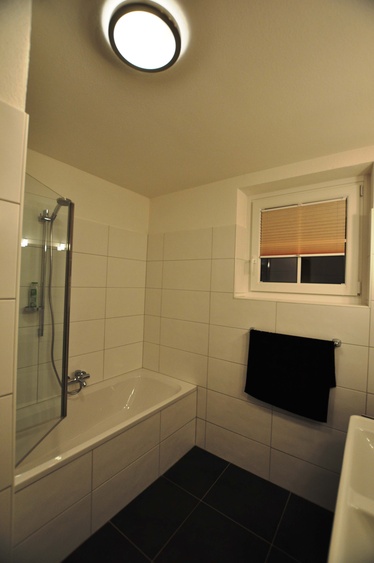 Badezimmer mit Bad mit Dusche und Doppelwaschbecken