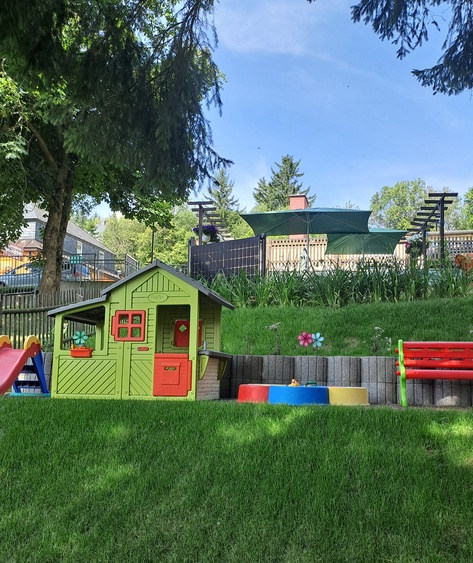 Spielehaus mit Rutsche und Sandkasten im Garten