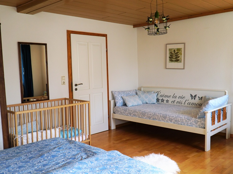Ferienhaus am Dorfbach - Schlafzimmer - ausgestattet mit Kinderbett, Einzelbett und Doppelbett