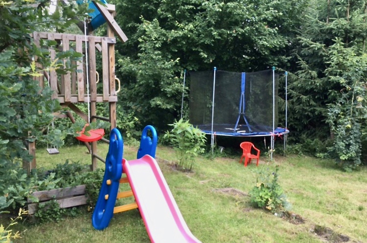 Paradies für Kinder: Spielplatz im Garten mit Schaukel, Rutsche, Kletterturm, Trampolin