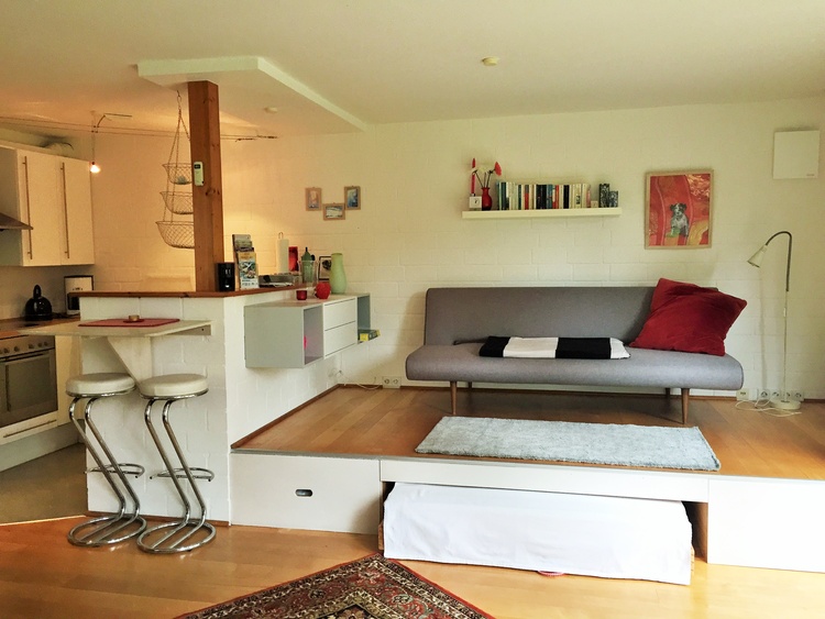 Das Bett wird unter dem Podest "geparkt". Auf dem Podest ein zusätzliches ausklappbares Sofa