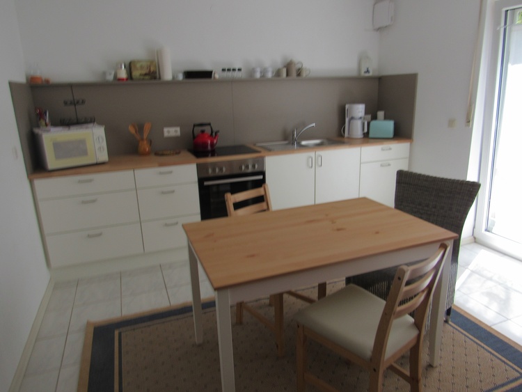 Küche mit Küchenzeile und Tisch mit Stühlen